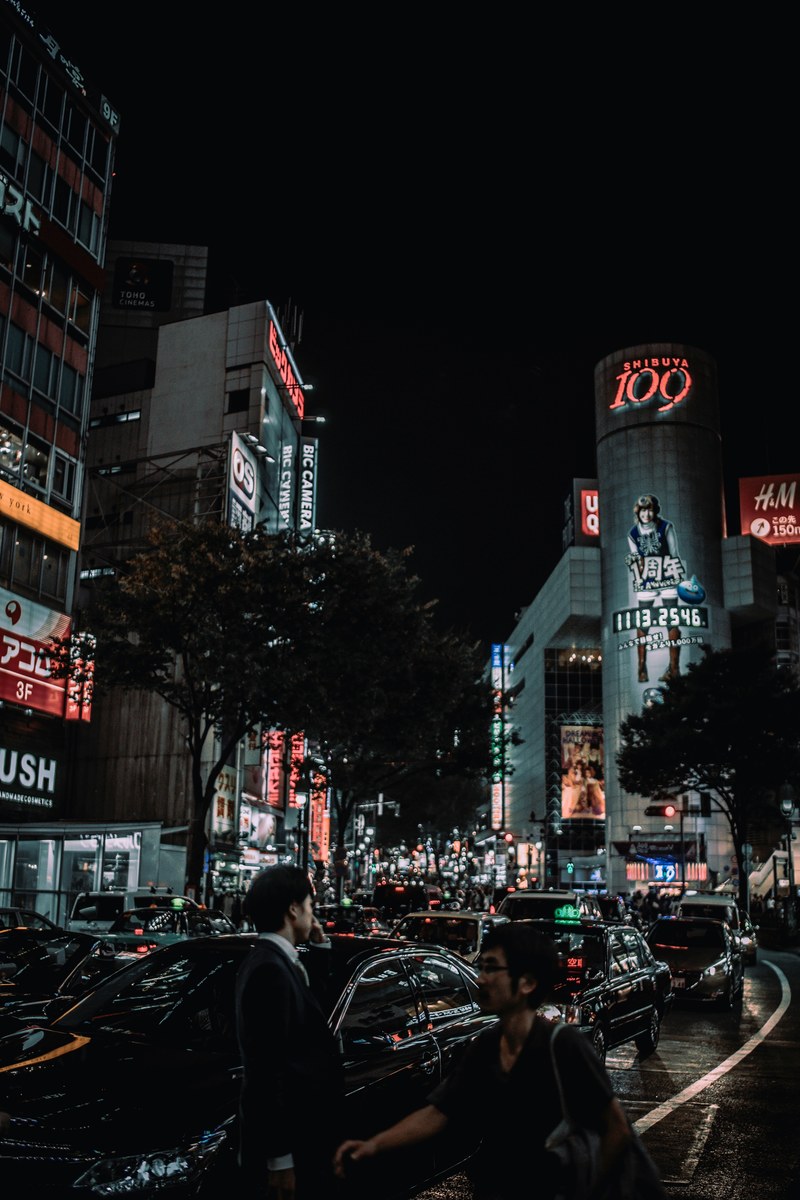 busy urban streets with pedestrians and neon building store signs in shibuya crossing at night, within these city walls 4k