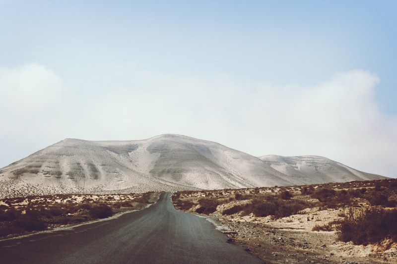 rural road leads to mountains through a desolate desert, road in the wilderness 4k