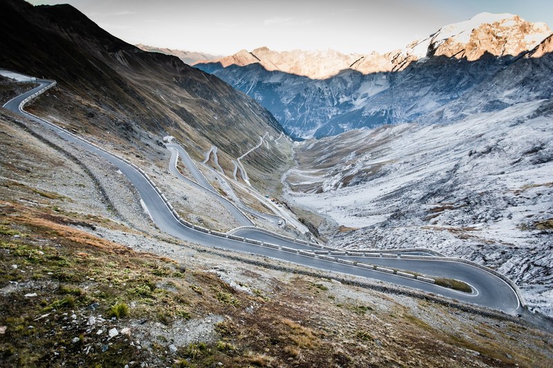 a mountain road winding down the foot of a valley, serpentine mountain road 4k