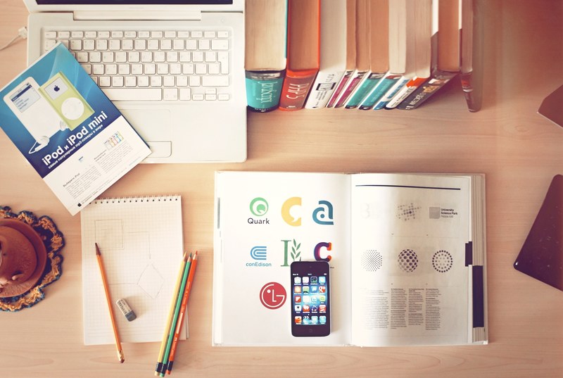 the top view of creative designers office showing books pencils laptop and iphone on a desk, books pencils laptop and iphone on a desk 4k