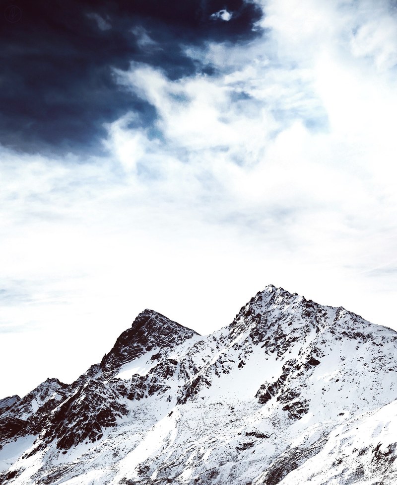 a mountain peak in the snow with a dramatic cloudy sky, snow capped mountain in the sky 4k
