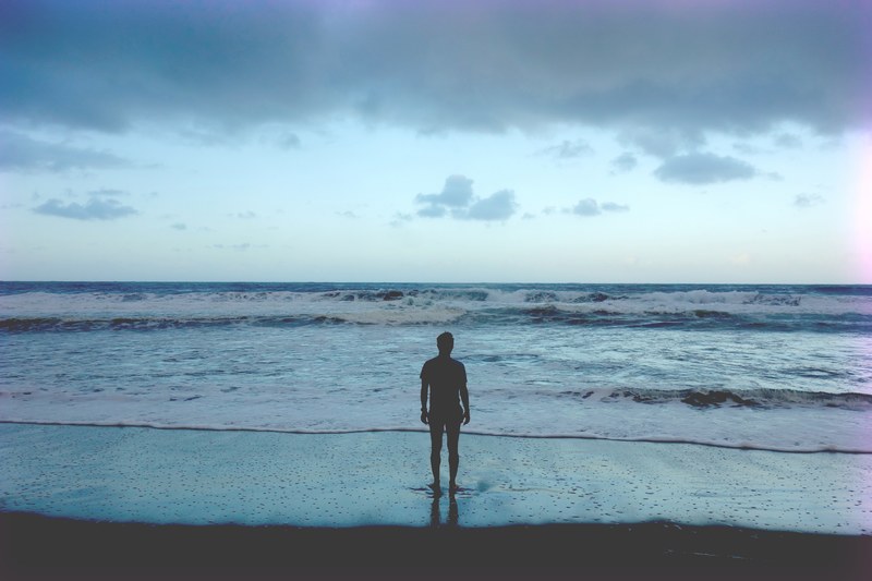 man silhouette standing on the beach looking at the ocean in waipio valley, silhouette on the beach 4k