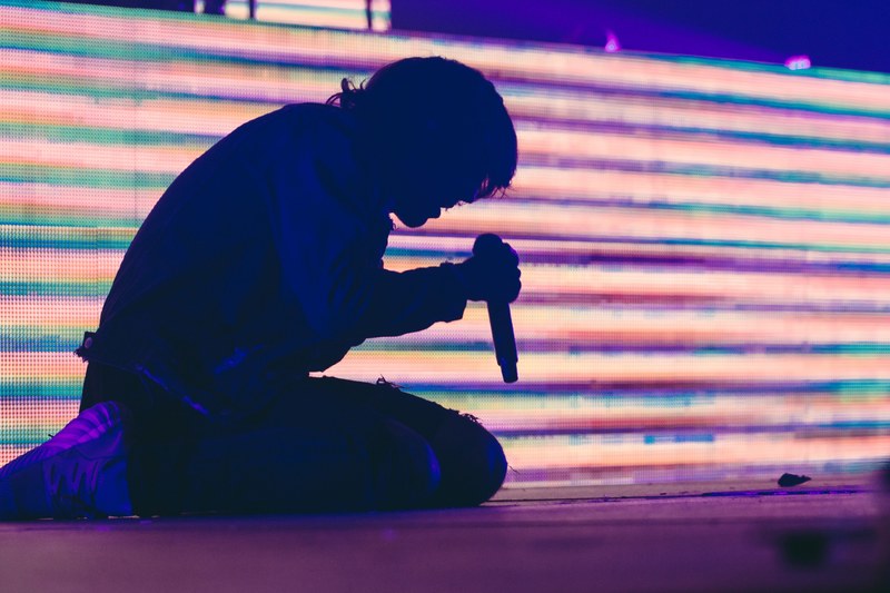 a musician kneeling on stage and singing into the microphone, bring me the horizon montreal 2017_ 4k