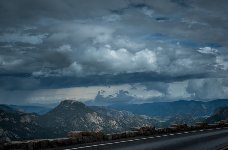 view from an asphalt road on a mountain valley under thick gray clouds, driving in the mountains 4k