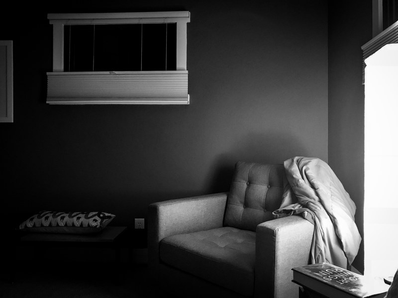 black and white living room with blanket on fluffy chair in the corner, black white chair blanket 4k