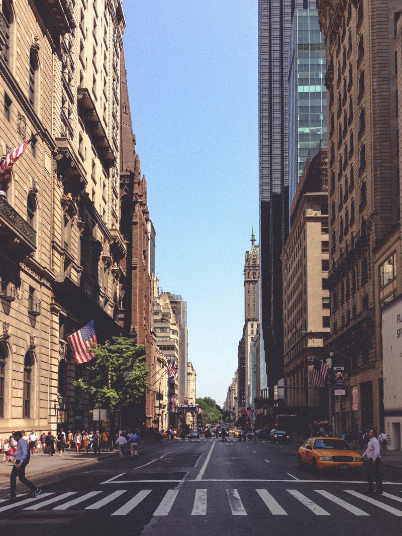 a crosswalk on a new york city street with skyscrapers on either side, three more blocks 4k