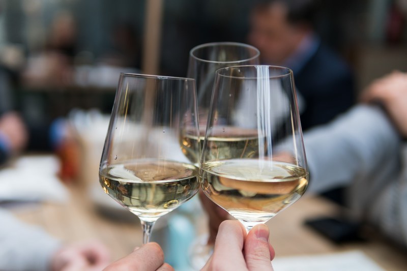 three people clinking their wine glasses, celebrating with white wine 4k