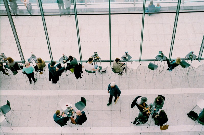 an overhead shot of people eating and talking at tables in a public space, people at lunch from above 4k