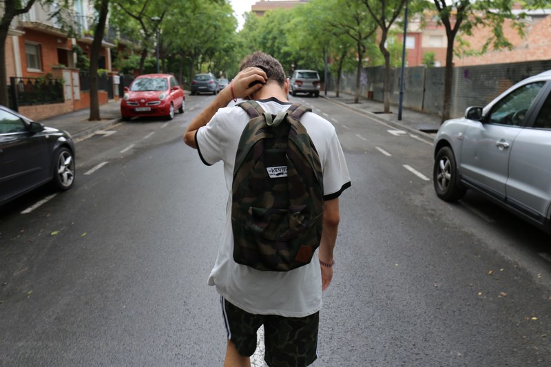 teen boy walking home from school wearing a backpack, not a known avenue 4k