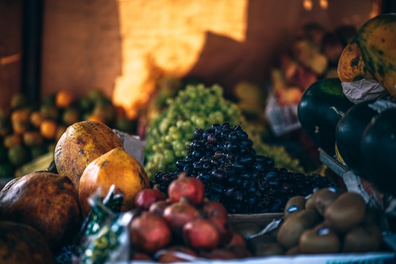 an assortment of various fruits and produce at a marketplace stall including guavas grapes coconuts and kiwi, heaps of grapes 4k