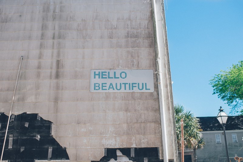 green hello beautiful sign on urban wall with blue sky in background charleston, hello beautiful sign on building 4k