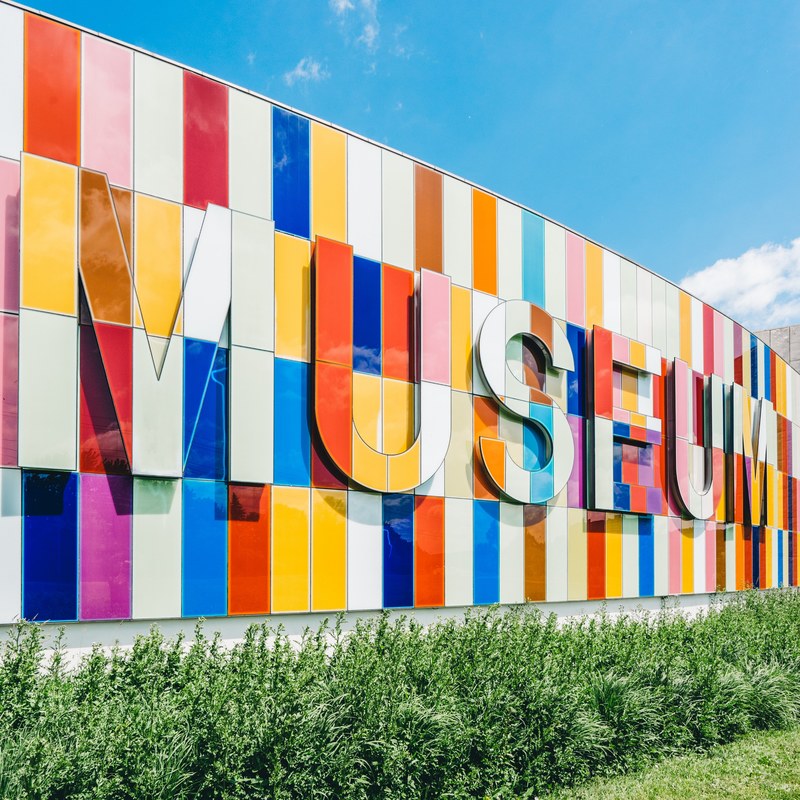 colorful tile sign of museum typography text sign near grass with blue sky waterloo region museum, colorful museum sign 4k