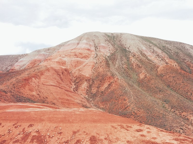 red sand forms a tall mountain formation in the desert, red desert mountains 4k