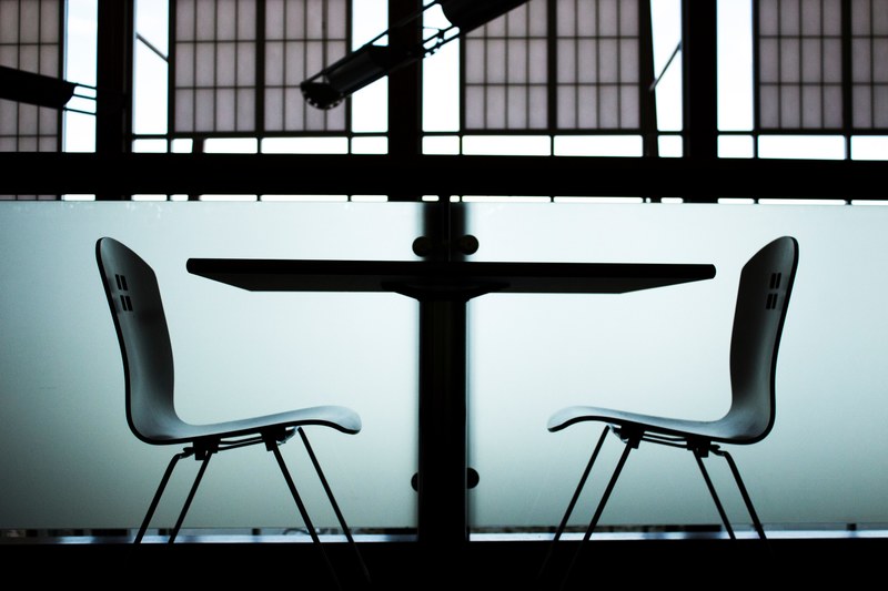 a gloomy side shot of two chairs on two sides of a table, conversation table 4k
