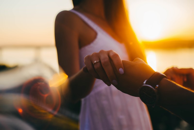 a woman in a white dress holds her partners hand displaying her engagement ring, engagement 4k