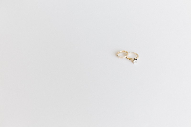 delicate gold wedding rings sit on a minimalist white surface, wedding rings on white surface 4k