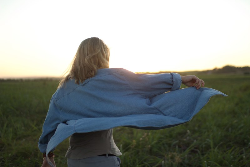 woman in a blue shirt against a sunset in a field at salt rock, woman at salt rock_ 4k