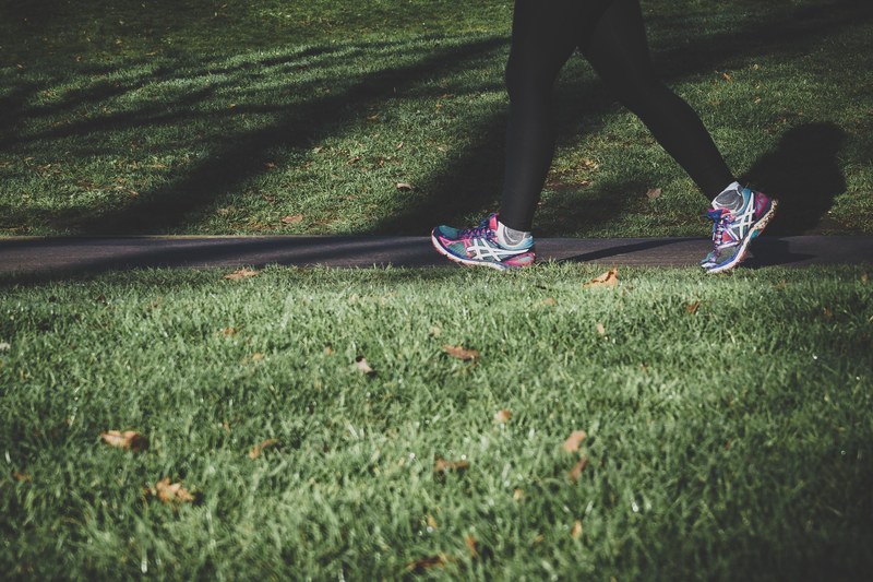 a person wearing leggings and sneakers walking on a path in london, keeping fit 4k