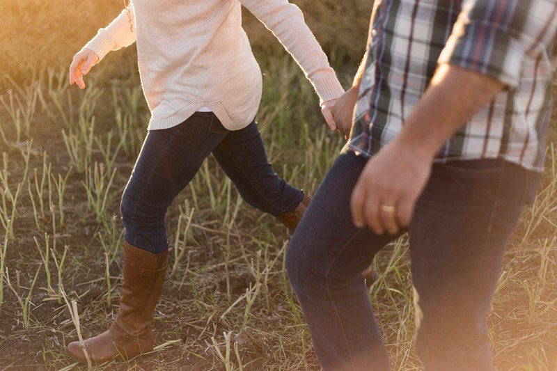 torsos of couple walking through a field, through the field 4k
