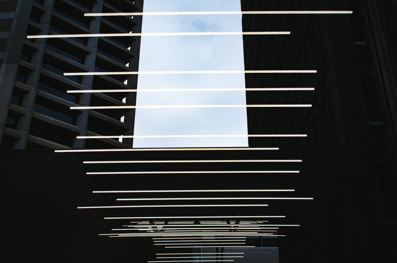 rows of light beams above a walkway between buildings, _light beams rows buildings 4k