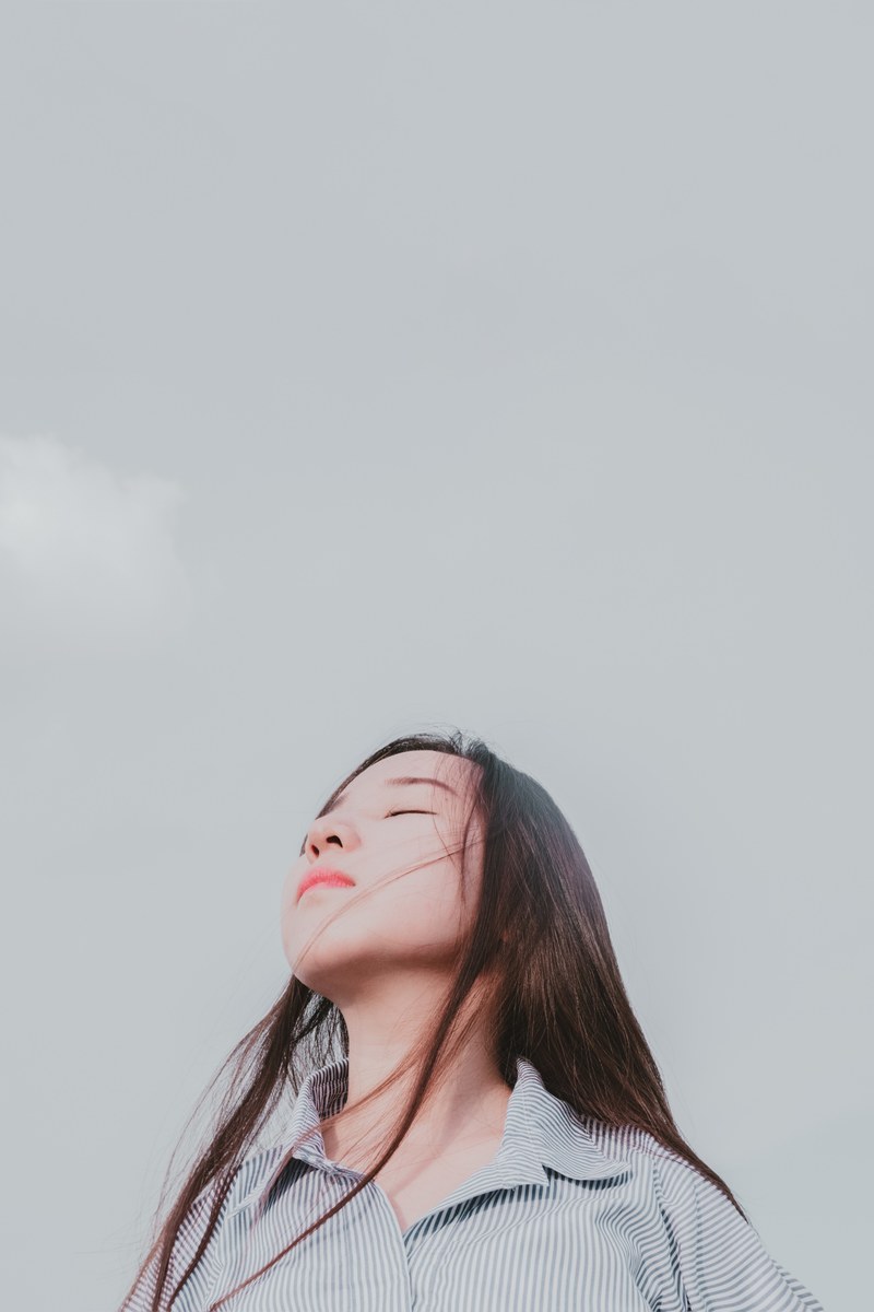 a woman closes her eyes and throws back her head toward the sky, closed_ 4k