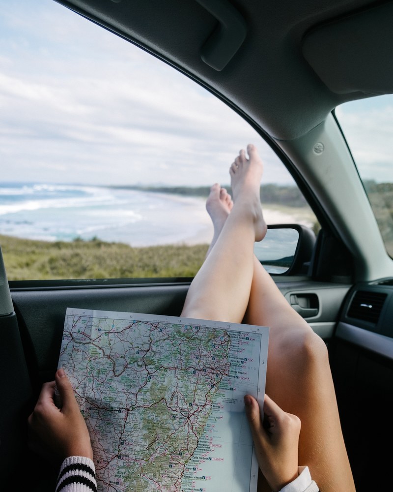 a woman reads a map with gold coast beach in the background, _woman map gold coast 4k