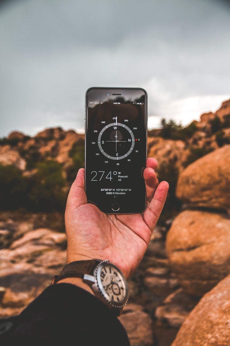 outstretched hand holds an iphone with a compass on a hike, getting lost on a walk 4k