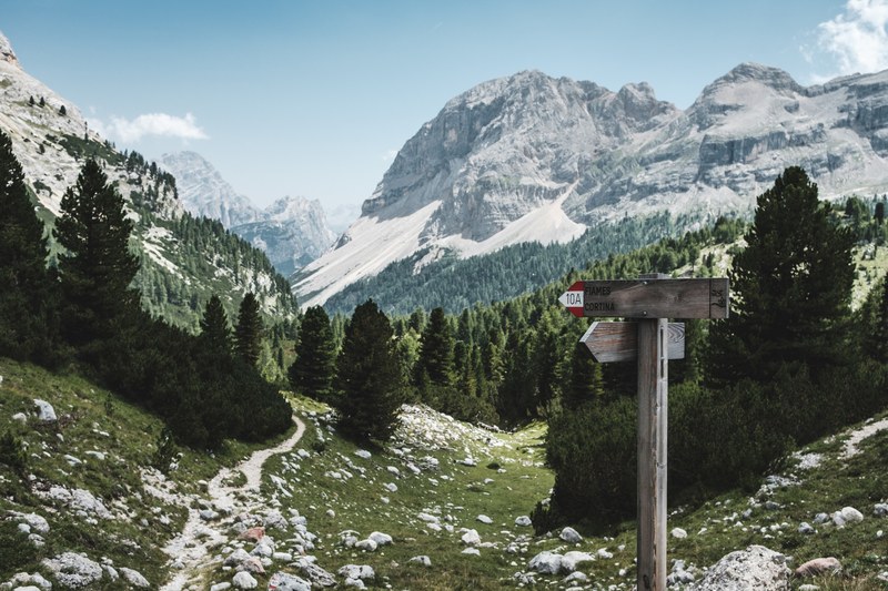 mountain landscape with signs pointing toward a rocky hiking path, mountain hiking path 4k