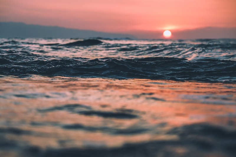 rippling ocean waves reflecting the light of the sunset at north shore, breath_ 4k