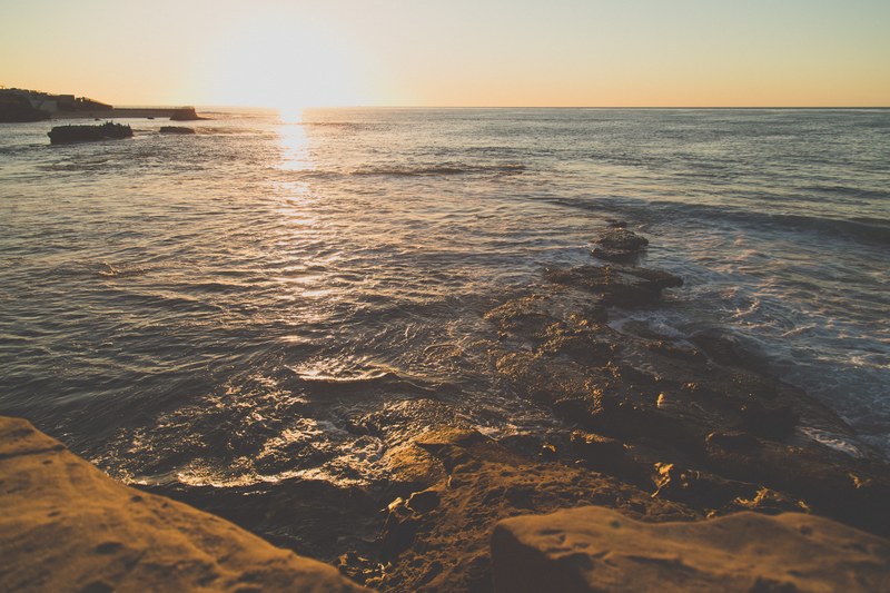 summer view of the sunbathed san diego ocean with steady clouds at sunset, sunset casts rays over ocean 4k