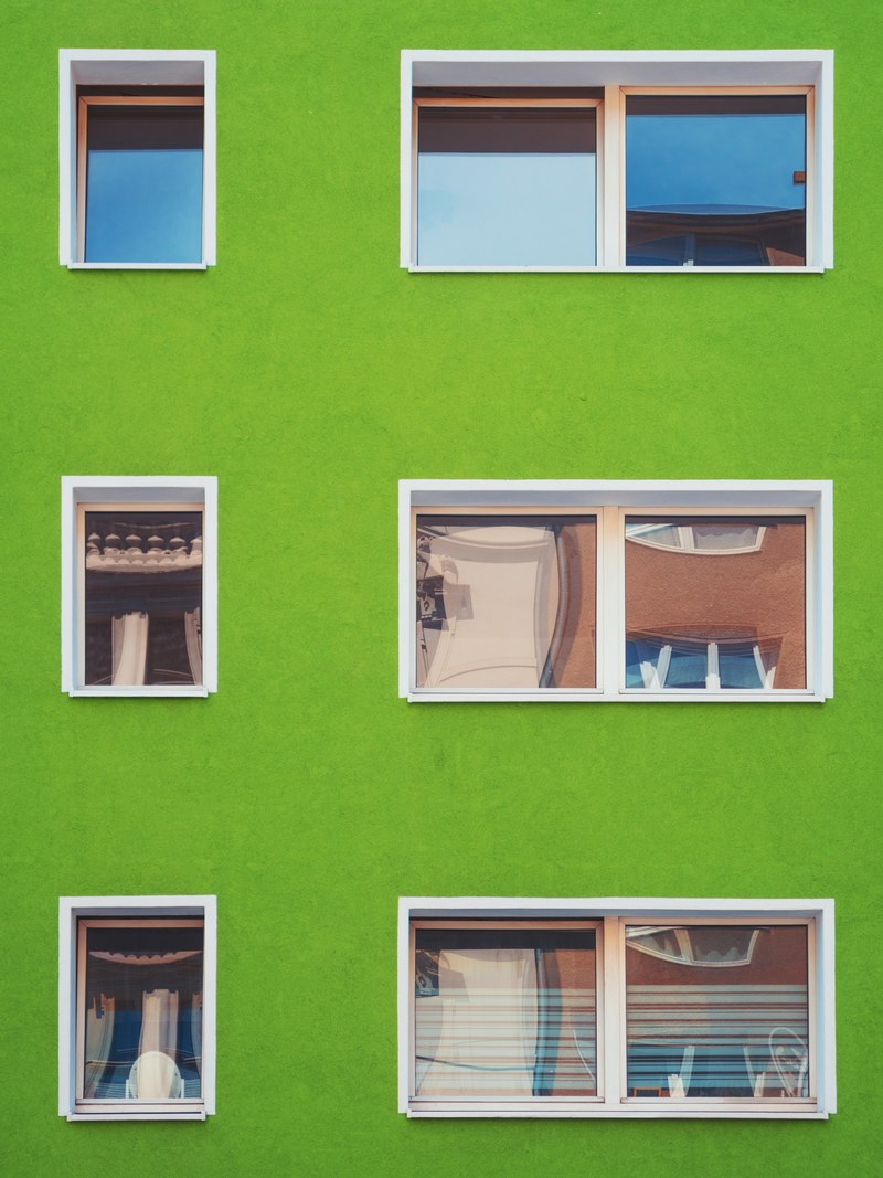 small windows in a green wall of a residential building in cologne, windows in a bright green wall 4k