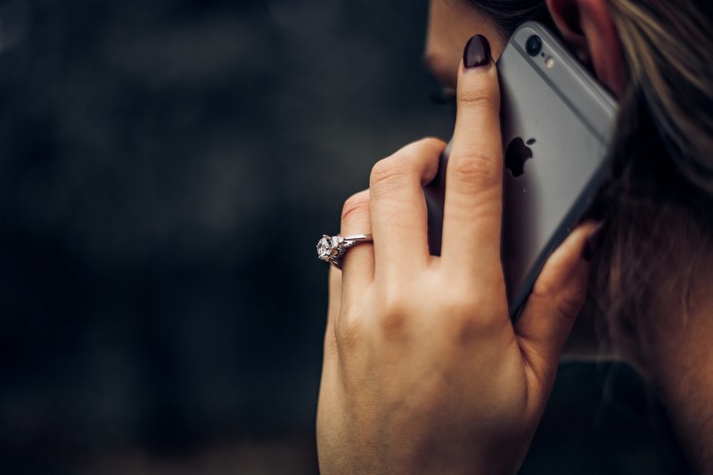 woman wearing a diamond wedding ring talking on an iphone, an engagement ring next to an iphone 6s 4k