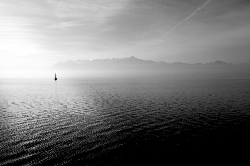sailboat sits on the horizon of a calm oceanscape, sailing on the horizon 4k