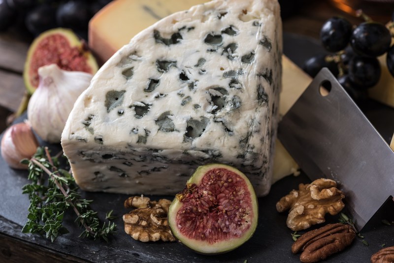 charcuterie board with a slice of blue cheese figs walnuts and garlic, rustic cheese plate 4k