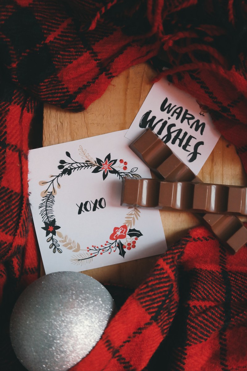 an xoxo note next to a gray christmas ornament and red plaid fabric, _xoxo christmas note 4k