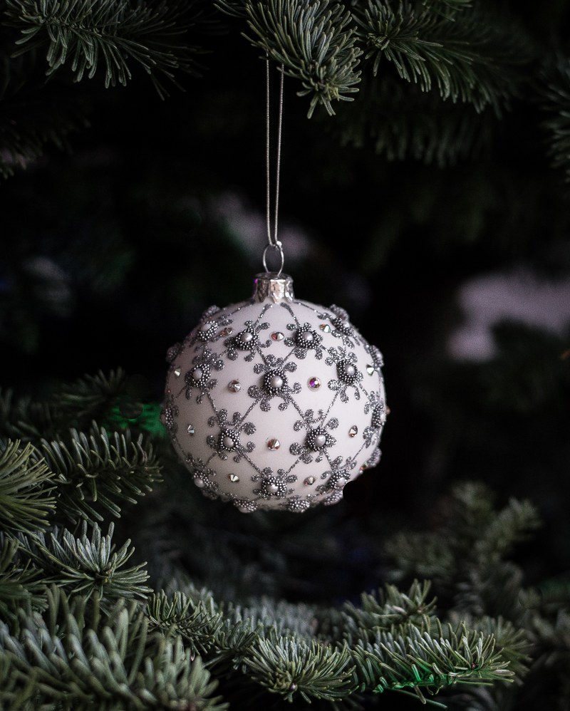 a white christmas ornament hanging from an xmas tree, _christmas ornament on tree 4k