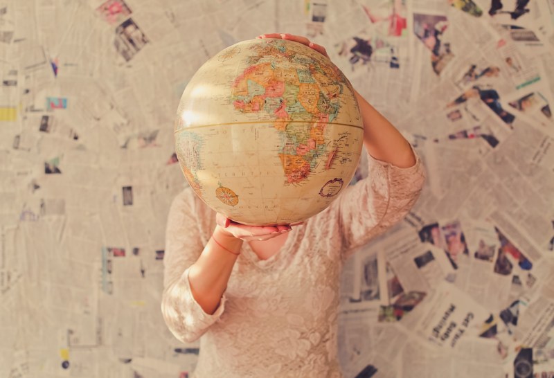 a woman in a lace blouse holding up a globe in front of her head, globe head 4k