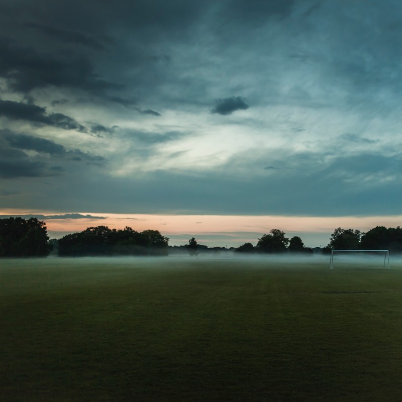 mist over a rural soccer field, soccer goal on a foggy field 4k
