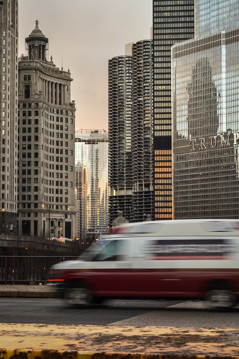 a blurry car on a bridge in a city with skyscrapers at the back, downtown bridge 4k