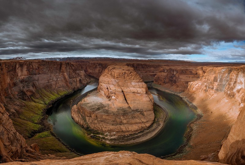 a horseshoe shaped river bend in a canyon under a stormy sky, storm over horseshoe bend 4k