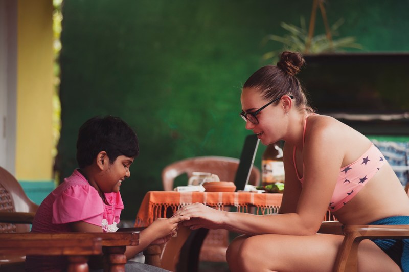 a woman and a child sitting in chairs opposite to each other and playing, woman playing with a child 4k