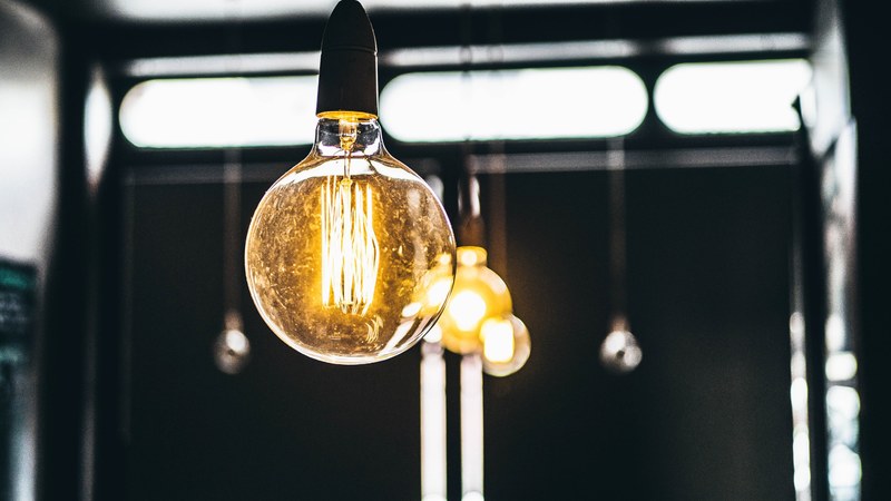 a round light bulb giving off warm light, tungsten light bulb 4k