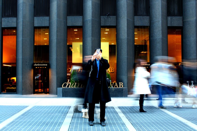 a man takes a photo facing the camera in front of the charles schwab bank, _person at charles schwab 4k