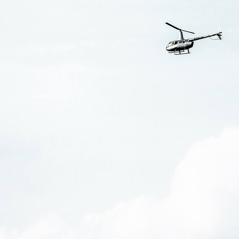 a white helicopter against a pale sky, silver helicopter 4k