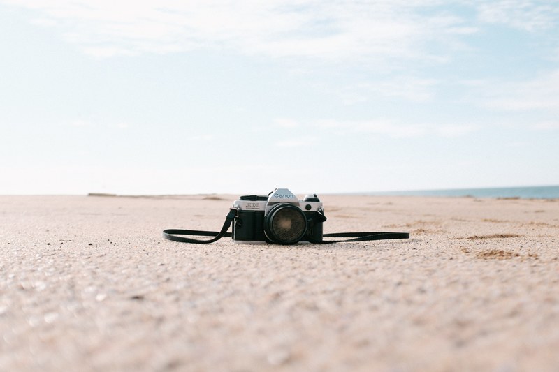 old analog slr canon camera at the sand beach in grindavik, analog slr camera on beach 4k