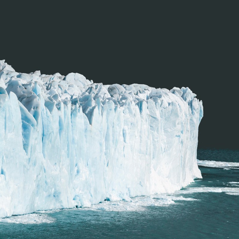 a giant wall of ice sits in the ocean against a dark sky, perito moreno glacier argentina_ 4k