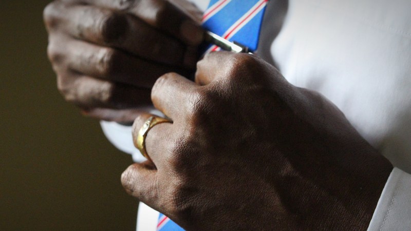 mans hands adjusting his red white and blue tie in cayman islands, fathers day 4k