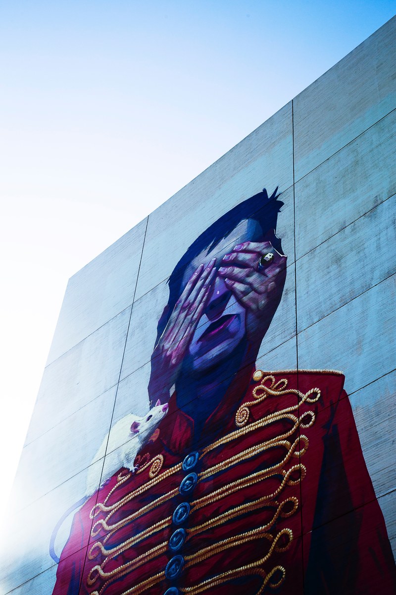 a wall painting of a marching band guys eyes covered by a set of hands, _marching band wall mural 4k