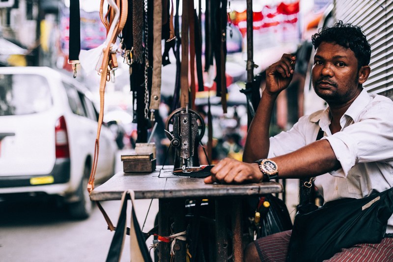 a burmese man selling belts at a table outside in yangon region, yangon region street vendor 4k