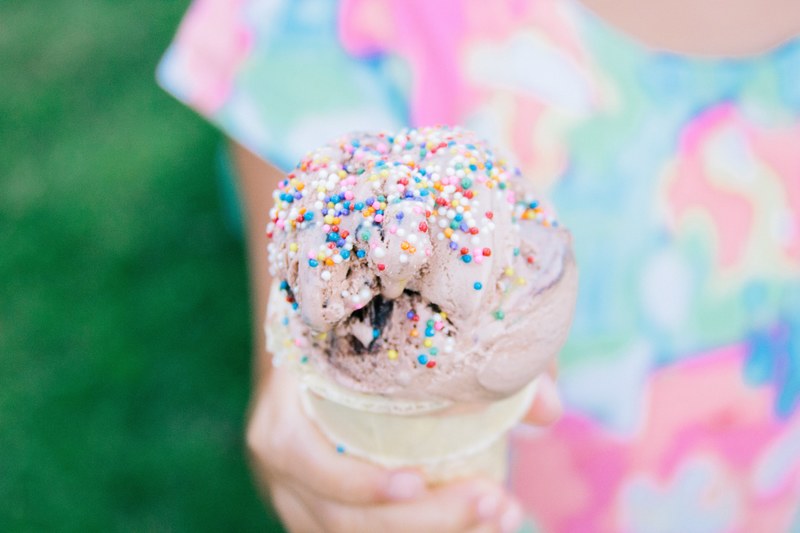 little girl holding ice cream cone with sprinkles 4k